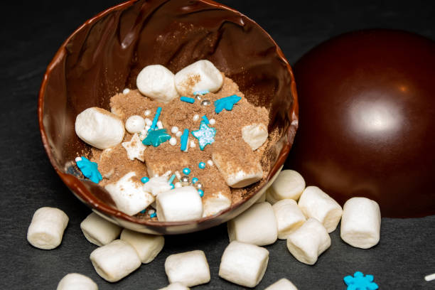 chocolate balls with cocoa and marshmallows in New Year's decoration on a black background.